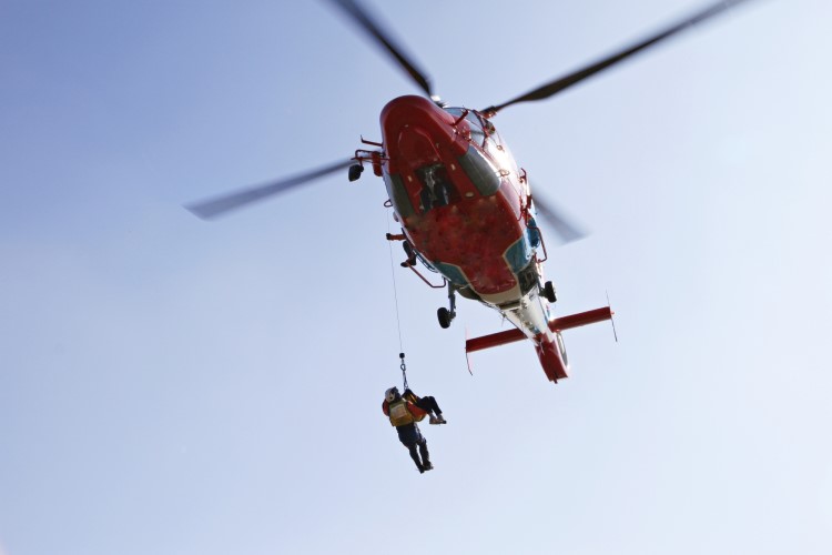 救助ヘリコプターで遭難者が救助隊に吊り上げられている遭難者救助時の写真